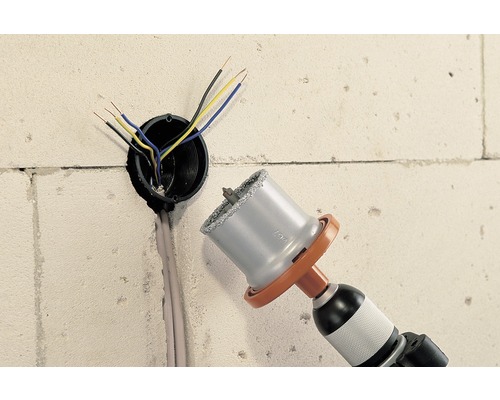 Mașină de găurit cu ferăstrău carotier care găurește un orificiu în perete pentru conductă electrică