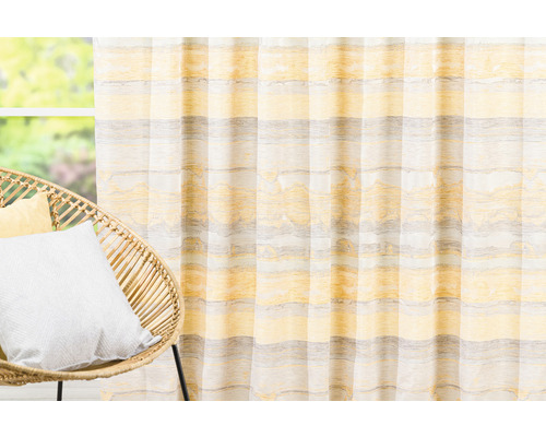 Șaluri decorative cu model în dungi în fața ferestrei și scaun din ratan