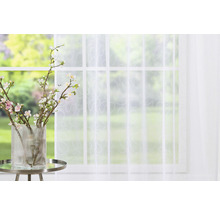 Șaluri decorative în fața ferestrei cu o vază cu flori pe masă