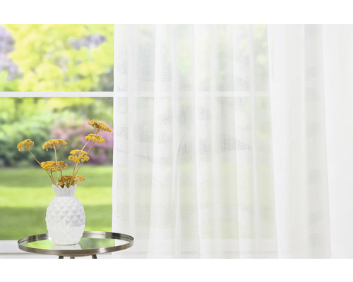 Scenă luminoasă și prietenoasă cu o perdea albă, transparentă în fața unei ferestre, o masă cu un aranjament floral