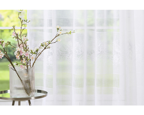 Cortină cu model floral în fața ferestrei