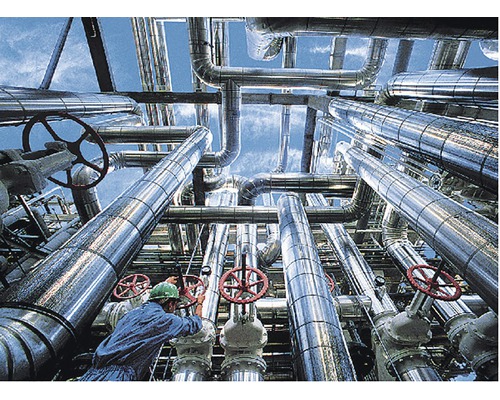 Instalație industrială cu țevi și valve, operată de un muncitor