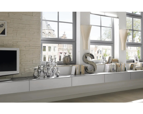 Living luminos cu mobilier alb, decorațiuni și ferestre mari.