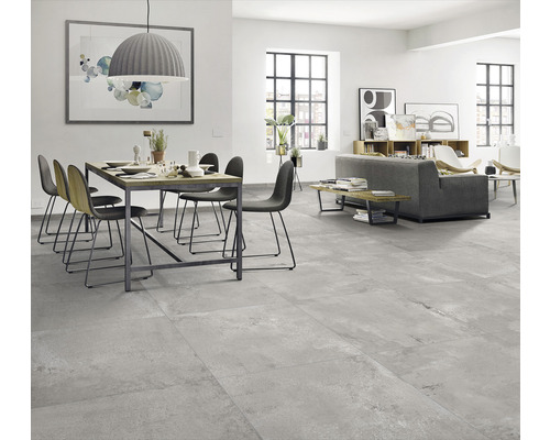 Cameră de zi luminoasă cu masă de sufragerie, scaune, canapea și pardoseală cu gresie.