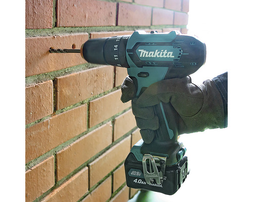 Mașină de găurit și înșurubat cu acumulator de la Makita găurind într-un perete de cărămidă