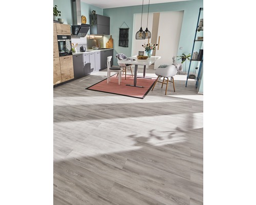 Bucătărie luminoasă cu masă, scaune și podea laminată.