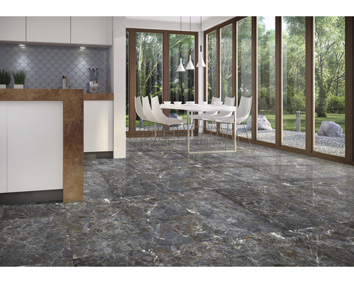 Cameră luminoasă cu podea cu gresie aspect de marmură, masă de sufragerie și bucătărie adiacentă.