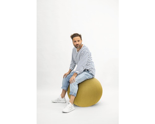 Bărbat stând pe o minge de gimnastică