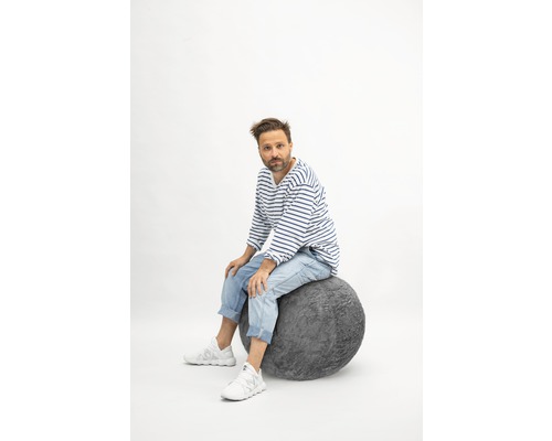 Bărbat așezat pe o minge gri de șezut