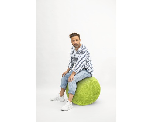 Bărbat stând pe o minge verde