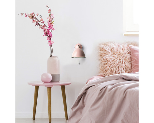 Dormitor cu noptieră, lampă de perete și decorațiuni