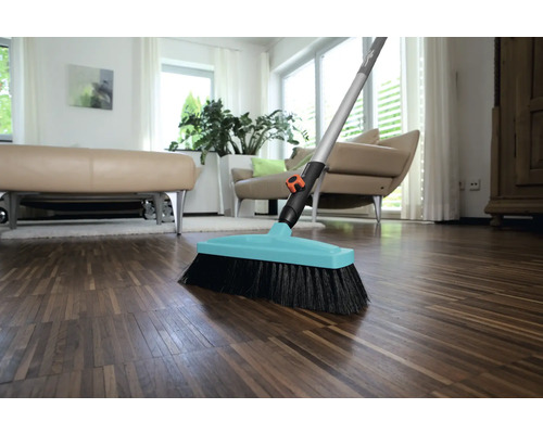 Mătură cu mâner pe podea de lemn într-o sufragerie