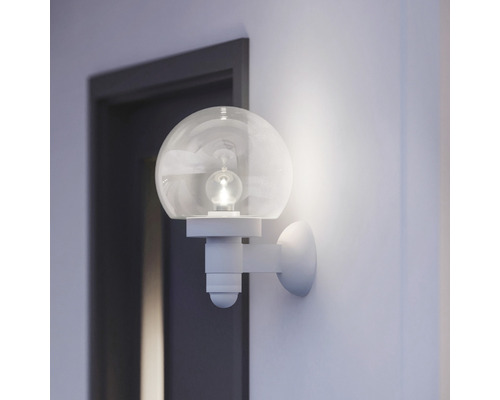 Lampa de perete cu glob de sticlă rotund într-o cameră luminoasă lângă o ușă
