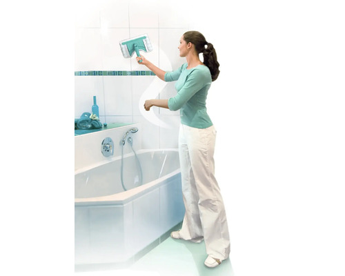 Femeie curățând faianța din baie cu o racletă de geamuri lângă o cadă