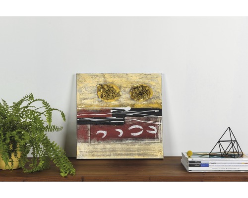 Tablou decorativ abstract de perete cu accente aurii pe o masă de lemn cu plantă și reviste