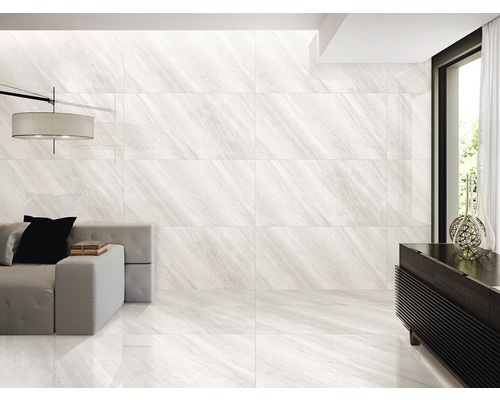 Cameră luminoasă cu gresie și faianță cu aspect de marmură, canapea și comodă