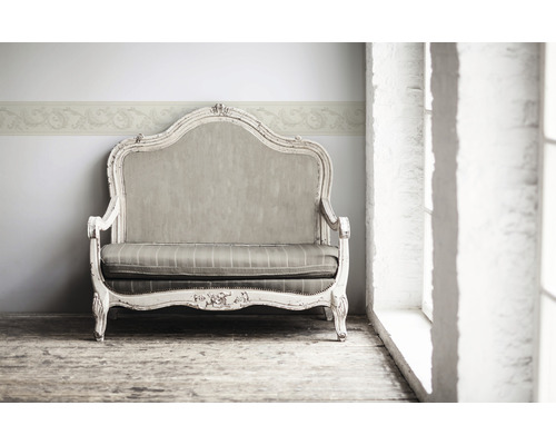 Canapea decorativă cu bordură florală pe perete pentru o ambianță elegantă în cameră.