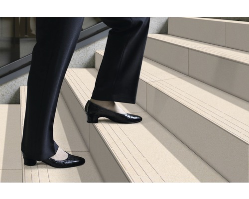 Persoană urcând scări cu benzi antiderapante