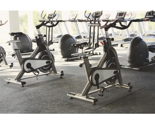 Sală de fitness cu mai multe biciclete staționare și benzi de alergare