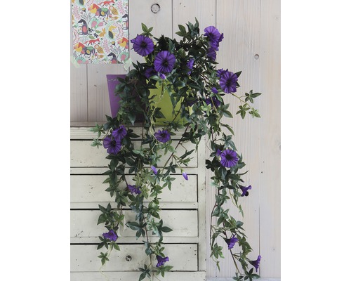 Plantă artificială decorativă de clematis cu flori violet într-un ghiveci pe o comodă