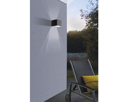 Lumină de perete cuboidală de exterior din metal cu fascicul luminos pe peretele casei