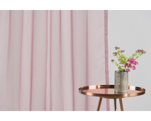 Cortină decorativă lângă o măsuță laterală cu flori într-o vază