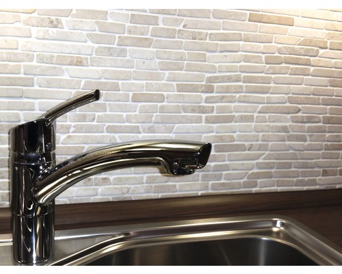 Chiuvetă de bucătărie cu robinet în fața unui zid de cărămidă