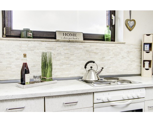 Scenă de bucătărie cu plită, ceainic, decorațiuni și ustensile de bucătărie pe un blat.