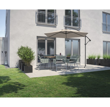 Scenă de grădină cu masă de sufragerie, scaune, umbrelă de soare și jardiniere pe o terasă