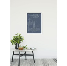 Imagine decorativă cu o schemă a navei spațiale X-Wing într-un cadru alb deasupra unei mese.
