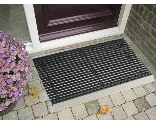 Covoraș de intrare în fața unei uși de intrare cu flori