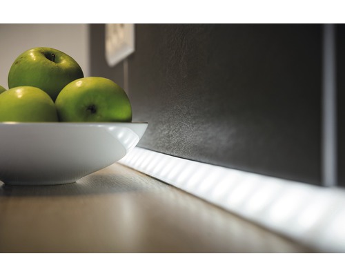 Scenă decorativă de bucătărie cu bandă luminoasă LED și un bol cu mere