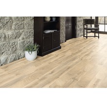 Podea din lemn deschis la culoare într-o cameră cu perete de piatră, dulap din lemn închis la culoare și scaun