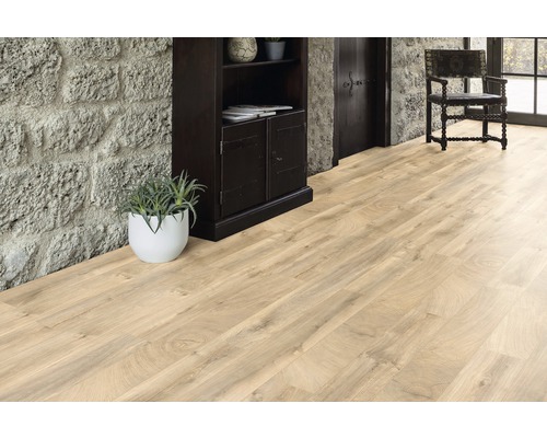 Podea din lemn deschis la culoare într-o cameră cu perete de piatră, dulap din lemn închis la culoare și scaun