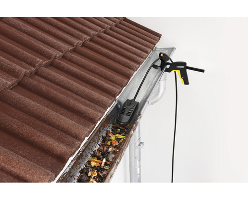 Curățător de jgheaburi în acțiune pentru a îndepărta frunzele și murdăria dintr-un jgheab