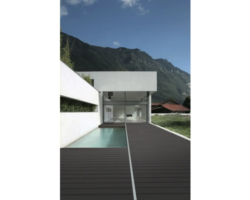 Fațadă modernă de casă cu piscină și terasă din lemn pe un fundal montan.