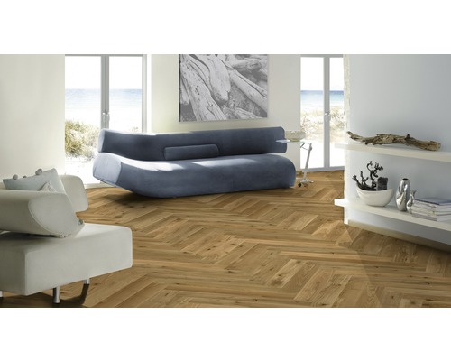 Living cu parchet herringbone, canapea și rafturi.