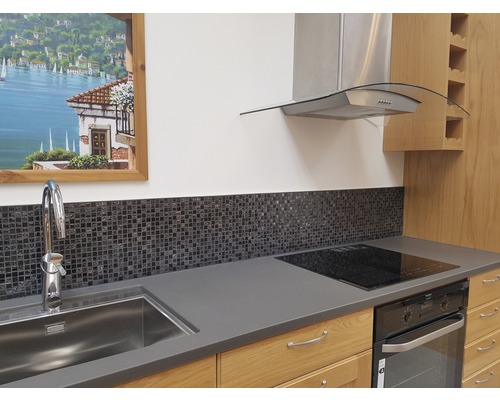 Scenă de bucătărie cu chiuvetă, baterie, plăci de mozaic, plită, cuptor și hotă.