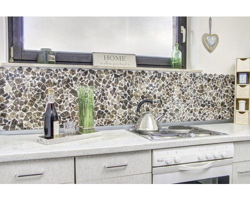 Scenă de bucătărie cu faianță mozaic ca protecție împotriva stropilor, plită și decorațiuni.