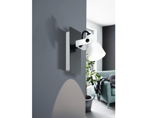 Lampa de perete în sufragerie cu un con de lumină pe perete