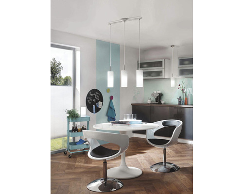 Bucătărie luminoasă cu masă de sufragerie, scaune și o lampă suspendată cu trei becuri