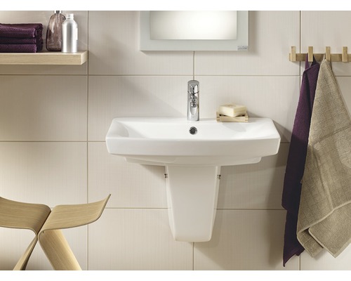 Baie luminoasă cu lavoar, robinet și prosoape pe o șipcă de lemn