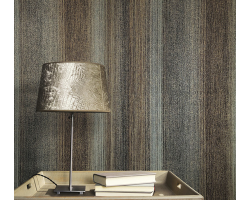 Prim-plan al unui perete cu tapet cu model în dungi, o masă cu o lampă și cărți