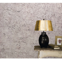 Prim-plan al unui perete cu tapet cu model abstract, o noptieră și o lampă