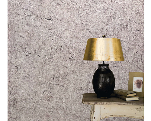 Prim-plan al unui perete cu tapet cu model abstract, o noptieră și o lampă