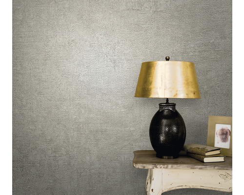 Prim-plan cu tapet texturat într-un living cu lampă de masă și decorațiuni