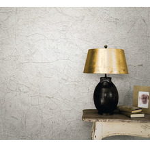 Scenă de locuit cu tapet structurat cu aspect de crăpături, lampă de masă și decorațiuni