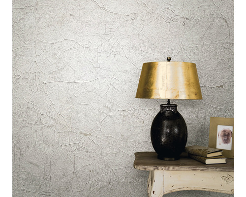 Scenă de locuit cu tapet structurat cu aspect de crăpături, lampă de masă și decorațiuni