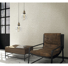 Cameră de zi cu fotoliu, masă și două corpuri de iluminat suspendate