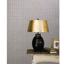 Scenă cu tapet textil, lampă și decorațiuni pe o masă